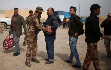 Displaced residents who fled their homes are searched by Iraqi troops as Iraqi forces battle with Islamic State militants, in western Mosul, Iraq March 28, 2017. REUTERS/Suhaib Salem