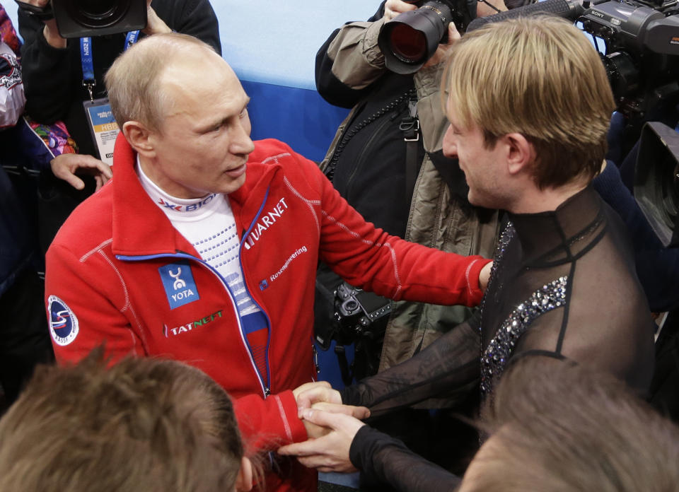 Russian President Vladimir Putin, left, shakes hands with Evgeni Plushenko of Russia as he congratulates the Russian team for their first place in the team figure skating competition at the Iceberg Skating Palace during the 2014 Winter Olympics, Sunday, Feb. 9, 2014, in Sochi, Russia. (AP Photo/David J. Phillip )