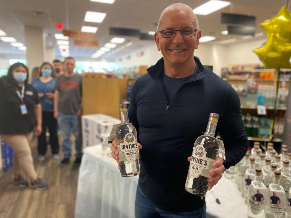 Robert Irvine signs bottles of his Irvine's Vodka and Irvine's Gin.