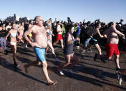 <p>People taking part in Coney Island’s annual New Year’s Day Polar Plunge race across the beach towards the water in New York, on Monday, Jan. 1, 2018. (AP Photo/Peter Morgan) </p>