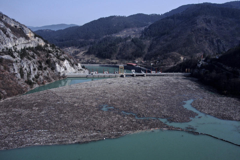 This aerial photo shows a dam garbage floating in the Drina river near Visegrad, eastern Bosnia, Wednesday, Feb. 24, 2021. Environmental activists in Bosnia are warning that tons of garbage floating down the Balkan country's rivers are endangering the local ecosystem and people's health. The Drina River has been covered for weeks with trash that has piled up faster than the authorities can clear it out. (AP Photo/Kemal Softic)
