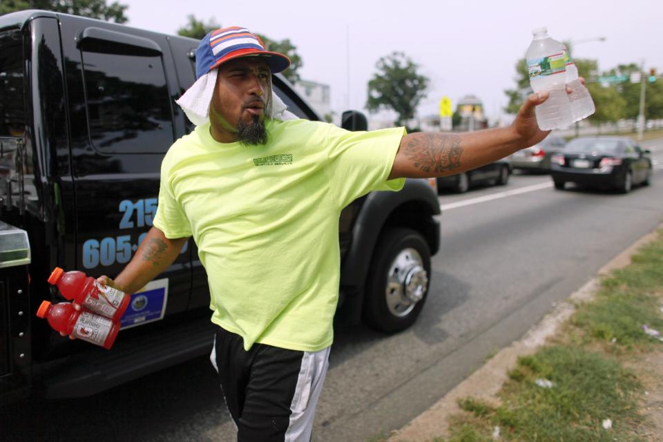 Frank Moralez sells cold beverages to motorists on the Roosevelt Boulevard, Saturday, July 7, 2012, in the Feltonville section of Philadelphia. Temperatures of more than 100 degrees were forecast in Philadelphia and excessive heat warnings were issued for several states in the Midwest as a heat wave continued. (AP Photo/Joseph Kaczmarek)