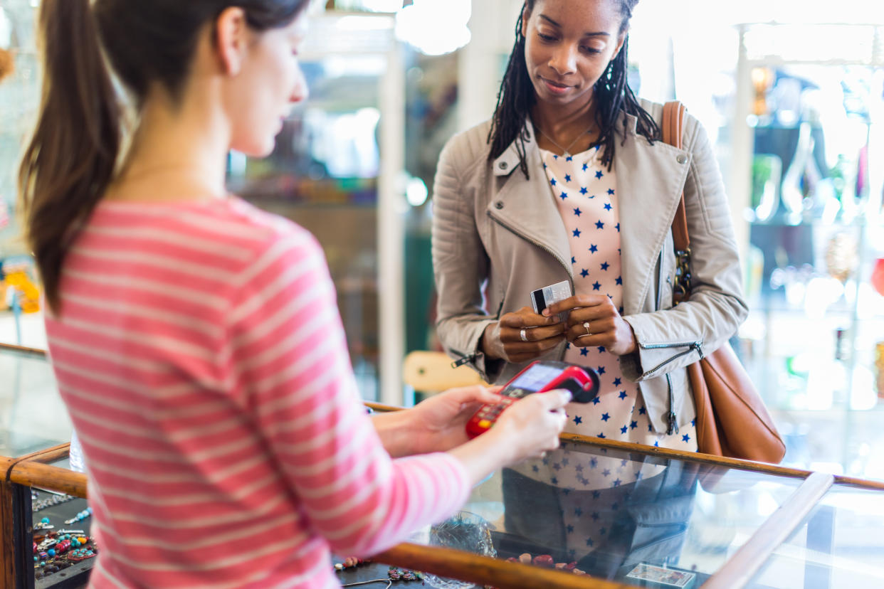 Woman paying for jewelry with contactless payment technology in a clothes store