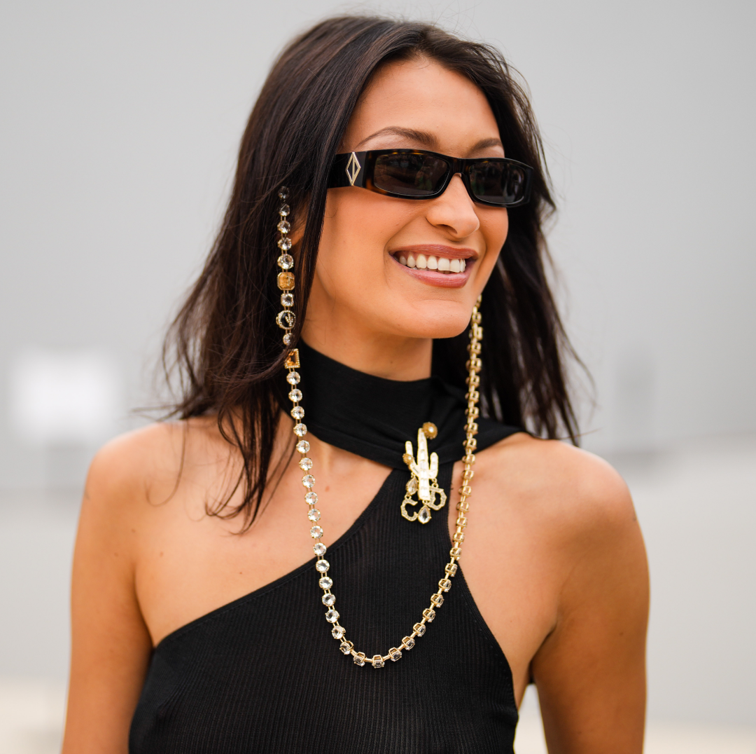  Bella Hadid wears sunglasses with a bejeweled / diamonds chain, a black off-shoulder cropped top with turtleneck, outside Dior, during Paris Fashion Week - Menswear Spring/Summer 2022, on June 25, 2021 in Paris, France. . 