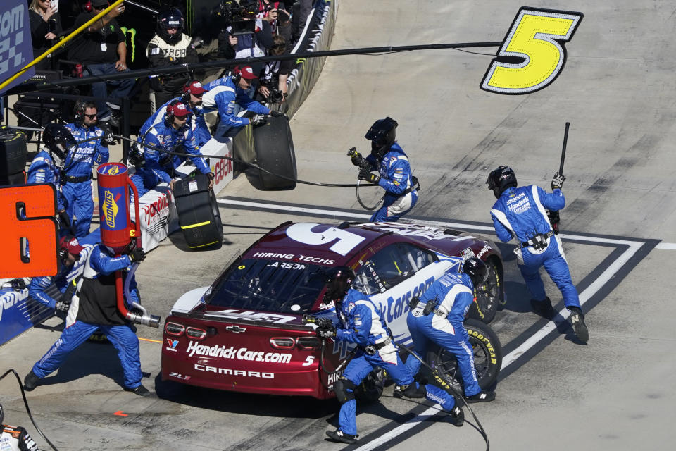 Crew members perform a pit stop on driver Kyle Larson's car during a NASCAR Cup Series auto race at Martinsville Speedway in Martinsville, Va., Sunday, April 7, 2024. (AP Photo/Chuck Burton)