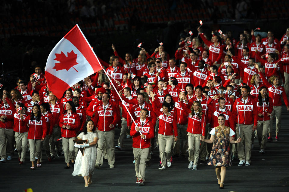 LONDON, ENGLAND - JULY 27: Simon Whitfield of the Canada Olympic triathlon team carries his country's flag during the Opening Ceremony of the London 2012 Olympic Games at the Olympic Stadium on July 27, 2012 in London, England. (Photo by Laurence Griffiths/Getty Images)