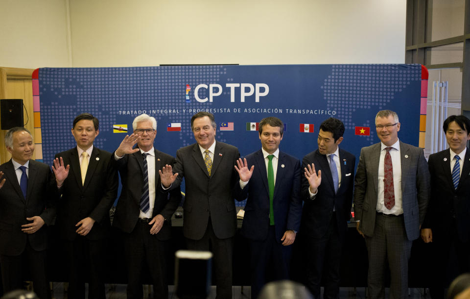 FILE - In this May 16, 2019, file photo, from left, Vietnam's Deputy Minister of Industry and Trade Tran Quoc Khanh, Singapore's Industry and Trade Minister Chan Chun Sing, Canada's Minister of International Trade Diversification James Carr, Chilean Foreign Minister Fernando Ampuero, Chilean Deputy Minister of Trade Rodrigo Yanez, Japan's Parliamentary Vice Minister of Foreign Affairs Kiyoto Tsuji, New Zealand's Minister for Trade and Export Growth David Parker, and Japan's Parliamentary Vice Minister of Economy, Trade and Industry Akimasa Ishikawa, wave as they pose for the group photo after a meeting of the Comprehensive and Progressive Agreement for Trans-Pacific Partnership, CP TPP, in Santiago, Chile. China has applied to join an 11-nation Asia-Pacific free trade group in an effort to increase its influence over international policies. (AP Photo/Esteban Felix, File)