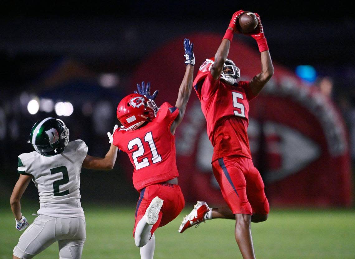 Sanger’s Marquis Cropper, right, intercepts a pass intended for Dinuba’s Dominique Nunez, left, in the first quarter Friday, Aug. 18, 2023 in Sanger. ERIC PAUL ZAMORA/ezamora@fresnobee.com