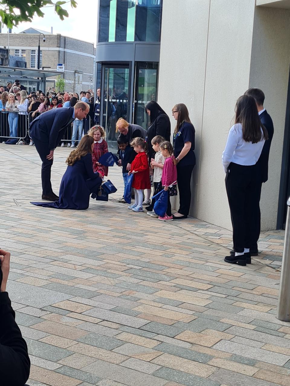 Prince William and Kate Middleton speaking with young children at the University of Glasgow.