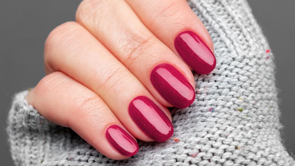 A hand with sparkly, red nails