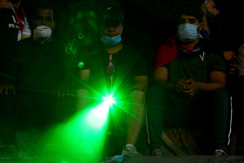 Iraqi demonstrators use lasers during the ongoing anti-government protests in Baghdad