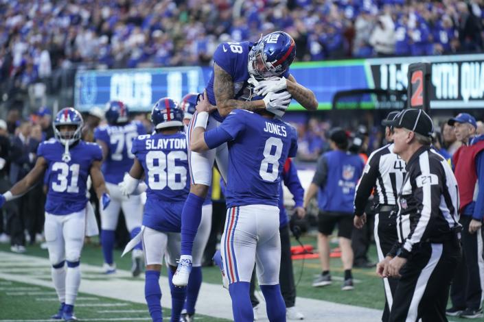 New York Giants' Isaiah Hodgins (18) celebrates with quarterback Daniel Jones (8) after Jones rushed for a touchdown during the second half of an NFL football game against the Indianapolis Colts, Sunday, Jan. 1, 2023, in East Rutherford, N.J. (AP Photo/Seth Wenig)