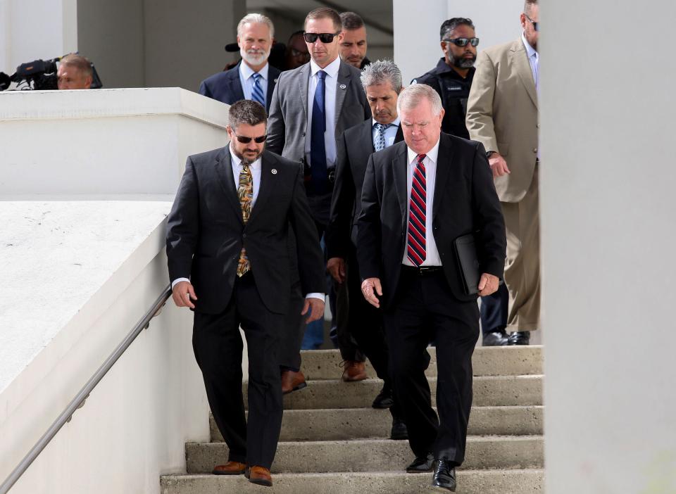 Larry Donald "Donnie" Murrell, Jr., (right) exits the Alto Lee Adams Sr. U.S. Courthouse on Tuesday, Aug. 15, 2023, after representing Carlos De Oliveira (middle) who entered a plea of not guilty to criminal charges in the classified documents case.