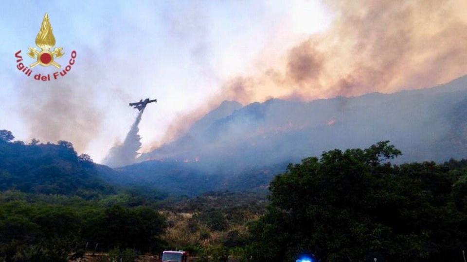 Einsatzkräfte der Feuerwehr kämpfen in der Region Palermo gegen Waldbrände.