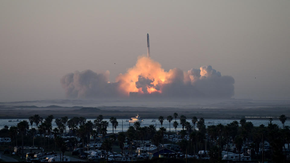  A photo of starship launching in the distance with massive plume of smoke. 