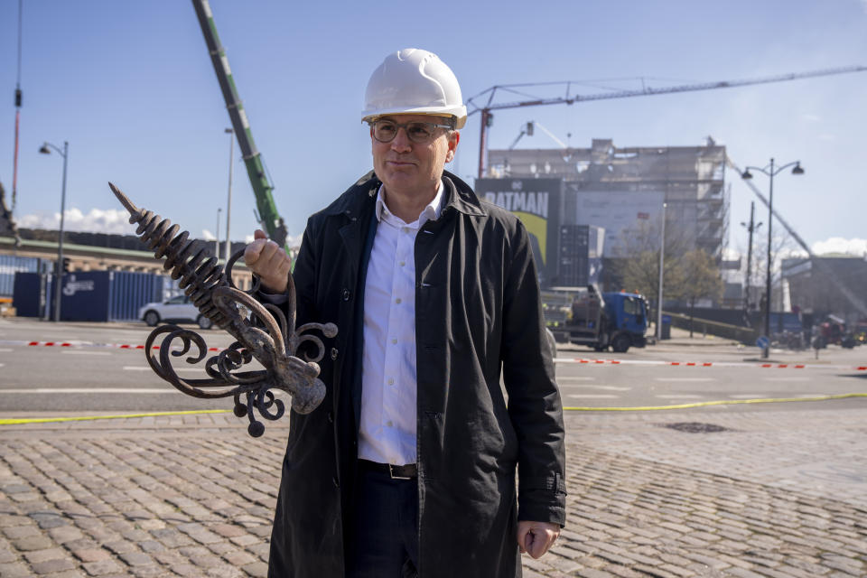 Danish Business' CEO Brian Mikkelsen holds the top of the burnt dragon spire in front of Boersen, The Stock Exchange building in Copenhagen Wednesday, April 17, 2024. A fire raged through one of Copenhagen’s oldest buildings on Tuesday, causing the collapse of the iconic spire of the 17th-century Old Stock Exchange as passersby rushed to help emergency services save priceless paintings and other valuables. (Ida Marie Odgaard/Ritzau Scanpix)