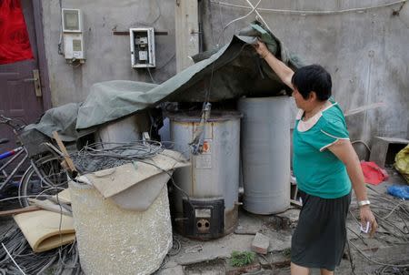 Villager Li Xiumei shows the abandoned coal-powered boilers in Xiaozhangwan village of Tongzhou district, on the outskirts of Beijing, China June 28, 2017. Picture taken June 28, 2017. REUTERS/Jason Lee