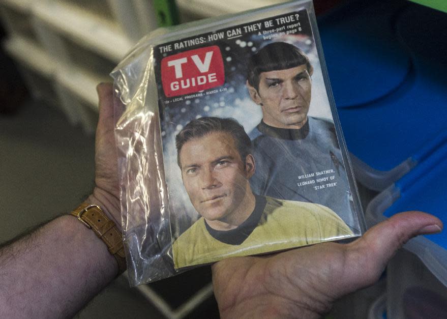 In this Friday, Nov. 30, 2012 photo, James Comisar holds an original TV Guide issue featuring William Shatner, and Leonard Nimoy of "Star Trek." The item is part of his television memorabilia collection in a temperature- and humidity-controlled warehouse in Los Angeles. (AP Photo/Damian Dovarganes)