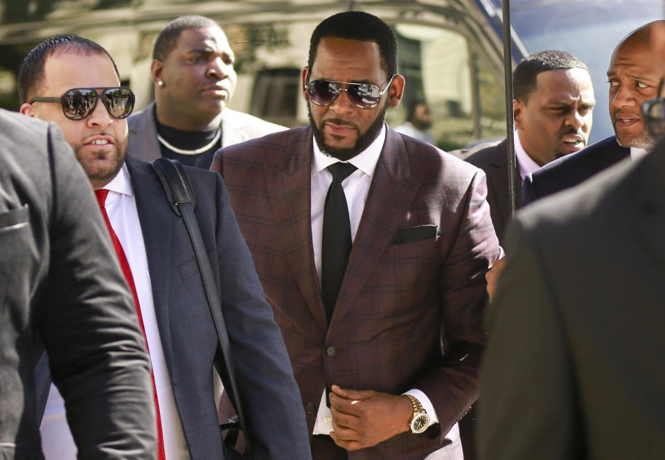 FILE - In this June 26, 2019, file photo, R&B singer R. Kelly, center, arrives at the Leighton Criminal Court building for an arraignment on sex-related felonies in Chicago. R. Kelly pleaded not guilty Friday, Aug. 2, 2019, in New York, to federal charges he sexually abused women and girls. The 52-year-old Kelly was denied bail in a Brooklyn courtroom packed with his supporters. (AP Photo/Amr Alfiky, File)