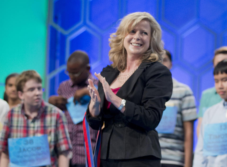 FILE - In this May 29, 2014 file photo, Paige Kimble, executive director of the Scripps National Spelling Bee, applauds during the Scripps National Spelling Bee at National Harbor in Oxon Hill, Md. Breaking from a tradition of being led by former contestants, the Scripps National Spelling Bee has hired a nonprofit leader with no history in the competition as its executive director, signaling a new era for the nearly century-old showcase for the top spellers in the English language. Cincinnati-based Scripps announced Monday, March 1, 2021, that J. Michael Durnil will take over immediately as bee director. He replaces Kimble, who stepped down last year. (AP Photo/Manuel Balce Ceneta, File)