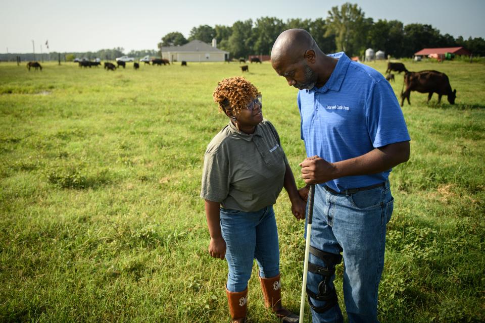 Marvin Frink, right, talks with his wife, Tanisha, in a pasture at the family cattle farm in Hoke County, North Carolina.