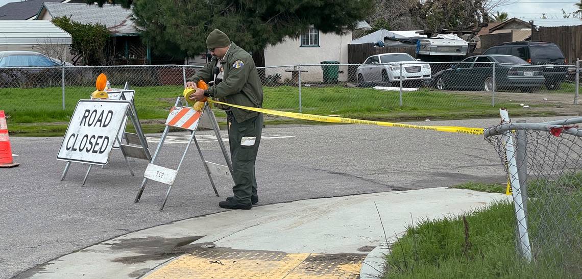 A Tulare County Sheriff’s Deputy cordons off a road, Tuesday, Jan. 17, 2023 as detectives continues to investigate a shooting that left six people dead early Monday morning in Goshen Calif. (Ron Holman/The Times-Delta via AP)