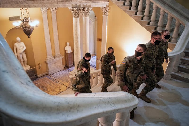 U.S. National Guard troops walk up the stairs in the U.S. Capitol in Washington