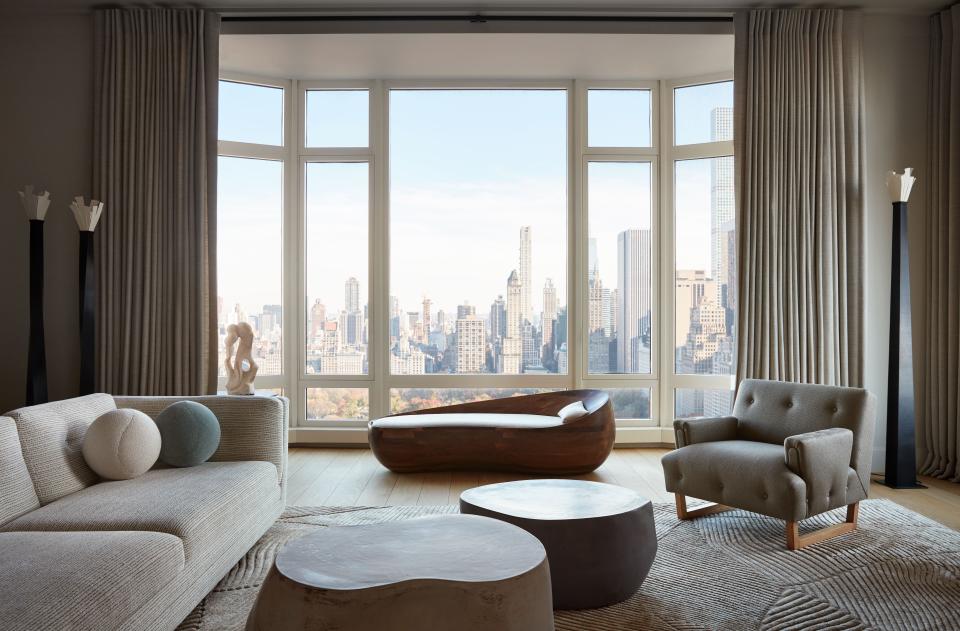 Yovanovitch and his clients decided to create a serene refuge from the bustling city, whose iconic skyscrapers are in full view from the living room’s ample windows, while also standing up to its strength. A combination of curvaceous and rectilinear shapes, and of glossy and matte surfaces, help to convey movement and energy. The neutral palette adds a sense of stillness. Two irregularly shaped coffee tables, designed by Yovanovitch and made by ceramicist Amelle Benoit, flow along with an oblong wooden daybed by Rasmus Fenhann. A rectangular sofa, also by Yovanovitch, pairs well with a 1950s armchair from Galerie Eric Philippe.