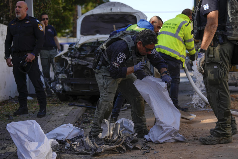 Israeli security forces inspect a site hit by a rocket fired from the Gaza Strip, in Holon, central Israel on Monday, Dec. 11, 2023. (AP Photo/Ariel Schalit)