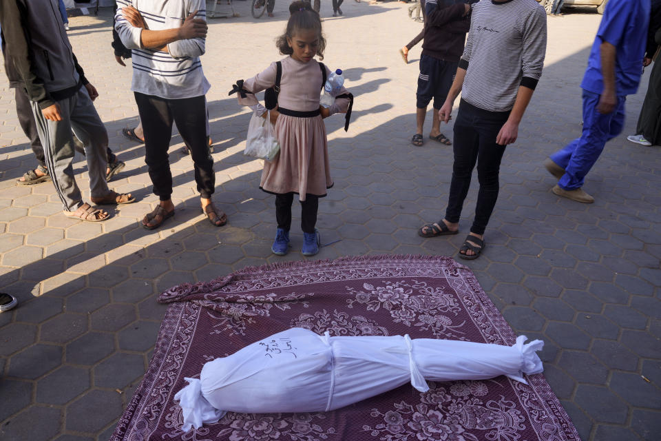 Palestinians mourn relatives killed in the Israeli bombardment of the Gaza Strip in front of the morgue in Deir al Balah on Monday, Dec. 4, 2023. (AP Photo/ Hatem Moussa)