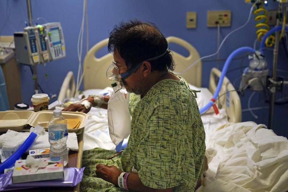 A COVID-19 patient eats his breakfast at St. Joseph Hospital in Orange, Calif., Thursday, Jan. 7, 2021. The state's hospitals are trying to prepare for the possibility that they may have to ration care for lack of staff and beds — and hoping they don't have to make that choice as many hospitals strain under unprecedented caseloads. (AP Photo/Jae C. Hong)