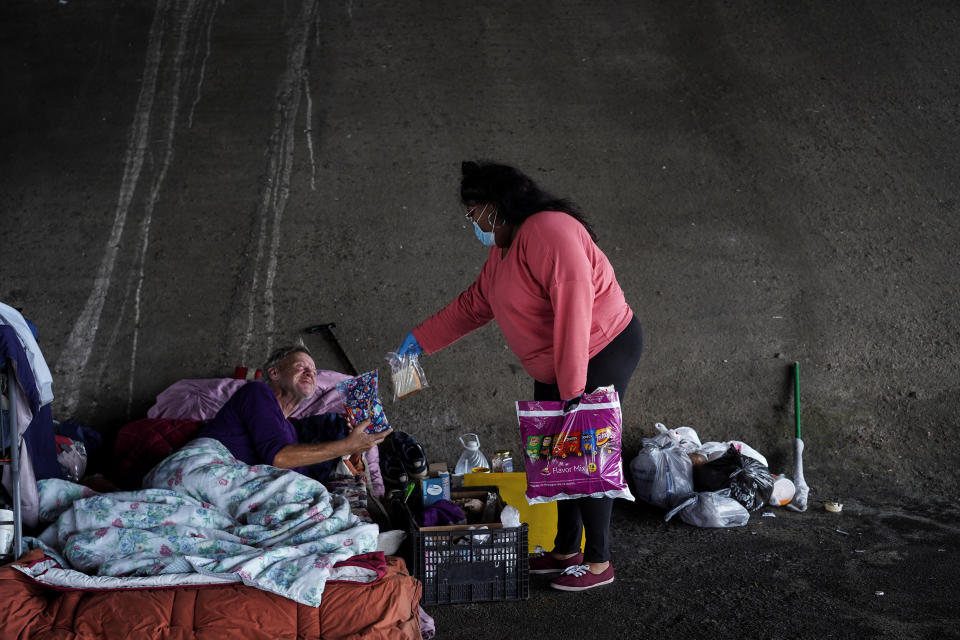 Dominick Walton, que también es una sin techo, da algo de comida a otras personas que viven en la calle en Houston, Texas. (REUTERS/Go Nakamura)