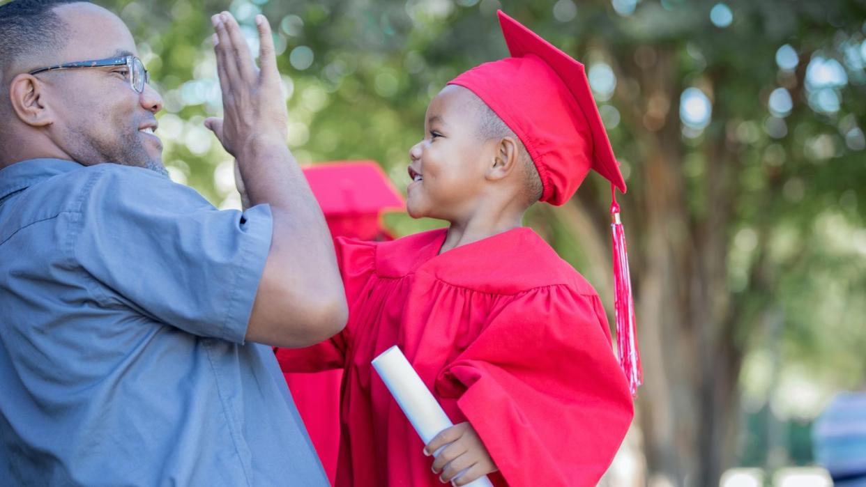 preschool graduate giving high five to dad