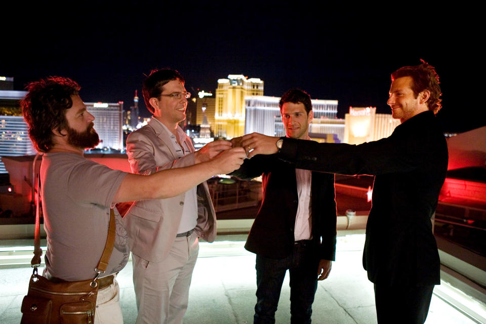 Zach Galifianakis, Ed Helms, Justin Bartha, Bradley Cooper in semi-formal attire cheersing on a Las Vegas rooftop
