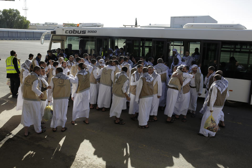 Yemeni prisoners gather during their arrival after being released by the Saudi-led coalition in the airport of Sanaa, Yemen, Thursday, Nov. 28, 2019. The International Committee of the Red Cross says over a hundred rebel prisoners released by the Saudi-led coalition have returned to Houthi-controlled territory in Yemen, a step toward a long-anticipated prisoner swap between the warring parties. (AP Photo/Hani Mohammed)