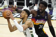 Milwaukee Bucks forward Giannis Antetokounmpo, left, drives against Phoenix Suns center Deandre Ayton during the second half of Game 5 of basketball's NBA Finals, Saturday, July 17, 2021, in Phoenix. (AP Photo/Matt York)