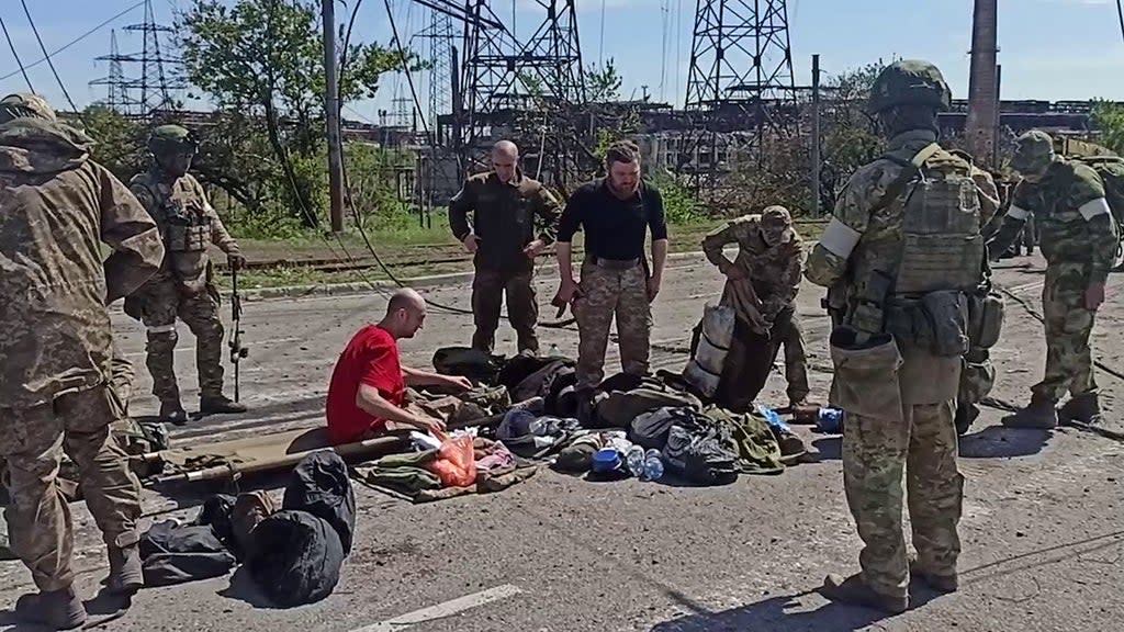 Ukrainian service members as they are searched by pro-Russian military personnel after leaving the Azovstal steel plant  (Russian Defence Ministry/AFP via)