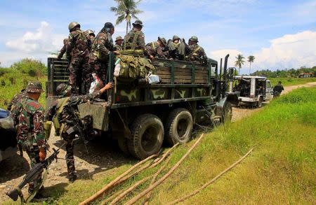 REFILE-REMOVING RESTRICTIONS A combined group of policemen and government forces board a military truck after Islamist militants, who had holed up in a primary school, retreated after a gunbattle with troops but were holding some civilians hostage, in Pigcawayan, North Cotabato, Philippines June 21, 2017. REUTERS/Marconi Navales TPX IMAGES OF THE DAY