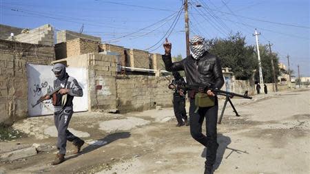 Gunmen fighters walk with their weapons in the streets of the city of Ramadi, 100 km (62 miles) west of Baghdad, January 21, 2014. REUTERS/Ali al-Mashhadani