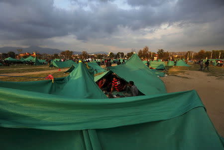 People sit inside their makeshift shelter on open ground after an earthquake in Kathmandu, Nepal April 26, 2015. REUTERS/Adnan Abidi