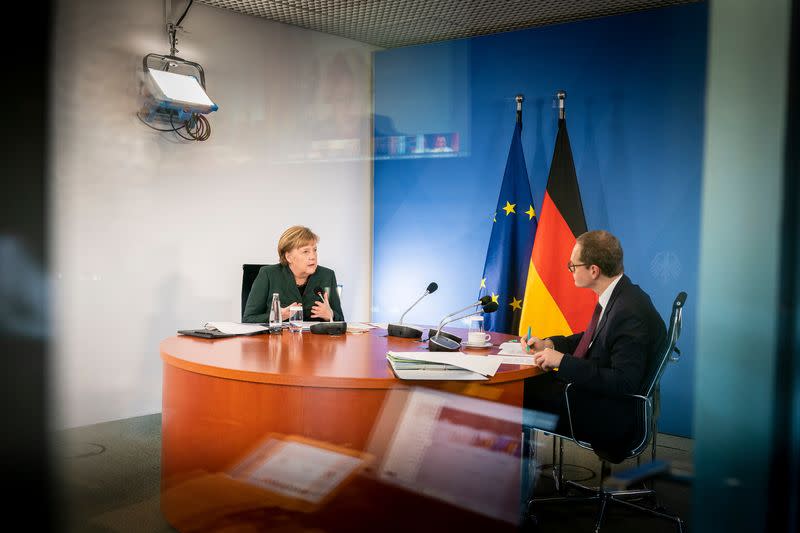 German Chancellor Angela Merkel and Berlin mayor Michael Mueller attend a video conference with state leaders at the Chancellery in Berlin