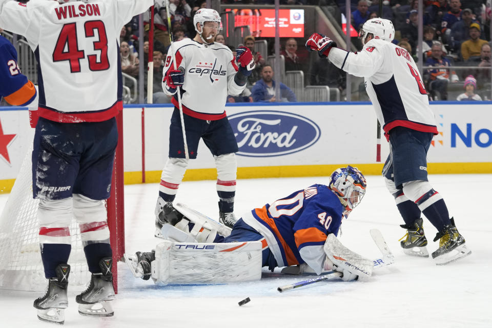 New York Islanders goaltender Semyon Varlamov (40) lies on the ice while Washington Capitals right wing Anthony Mantha (39) celebrates his goal with left wing Alex Ovechkin (8) during the third period of an NHL hockey game Saturday, March 11, 2023, in Elmont, N.Y. (AP Photo/Mary Altaffer)