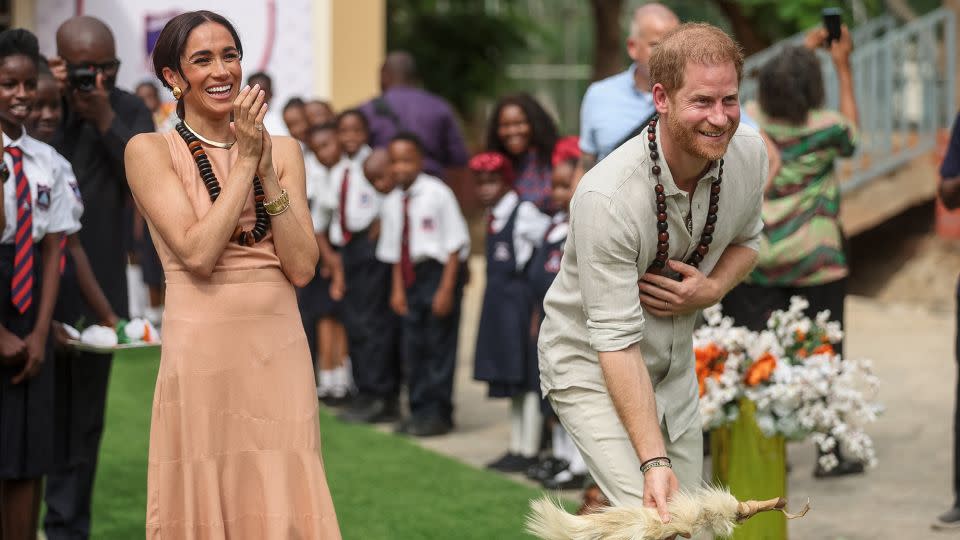 Britain's Prince Harry, Duke of Sussex, and Meghan, Duchess of Sussex, take part in activities as they arrive at the Lightway Academy in Abuja on May 10, 2024. - Kola Sulaimon/AFP/Getty Images