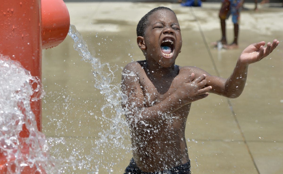 Javonte Gray, then 6, cools off in the water spray at the splash pad at the Charles H. Evans Community Center.