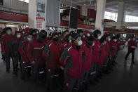 In this Tuesday, Feb. 18, 2020, photo, delivery workers for Chinese e-commerce giant JD.com prepare for the morning round of deliveries from a distribution center in Beijing, China. JD and rivals including Pinduoduo, Miss Fresh and Alibaba Group's Hema are scrambling to fill a boom in orders while protecting their employees. E-commerce is one of the few industries to thrive after anti-virus controls starting in late January closed factories, restaurants, cinemas, offices and shops nationwide and extinguished auto and real estate sales. (AP Photo/Ng Han Guan)