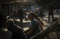 A man wearing a face mask to prevent the spread of coronavirus smokes in the street in Barcelona, Spain, Wednesday, Sept. 16, 2020. The Spanish capital will introduce selective lockdowns in urban areas where the coronavirus is spreading faster, regional health authorities announced on Tuesday. (AP Photo/Emilio Morenatti)