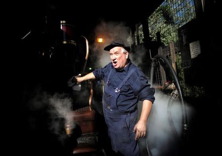 Puffing Billy steam engine driver Steve Holmes, 61, wipes down locomotive 12A as it gets up to steam before running his train from Belgrave station near Melbourne, October 20, 2014. REUTERS/Jason Reed