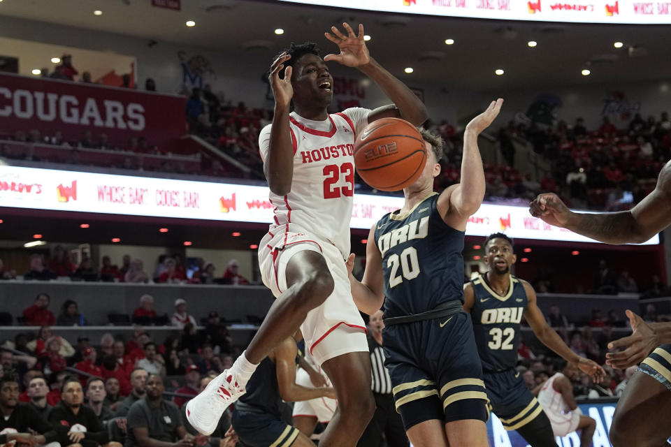 Houston's Terrance Arceneaux (23) is fouled by Oral Roberts's Trey Phipps (20) during the second half of an NCAA college basketball game Monday, Nov. 14, 2022, in Houston. (AP Photo/David J. Phillip)