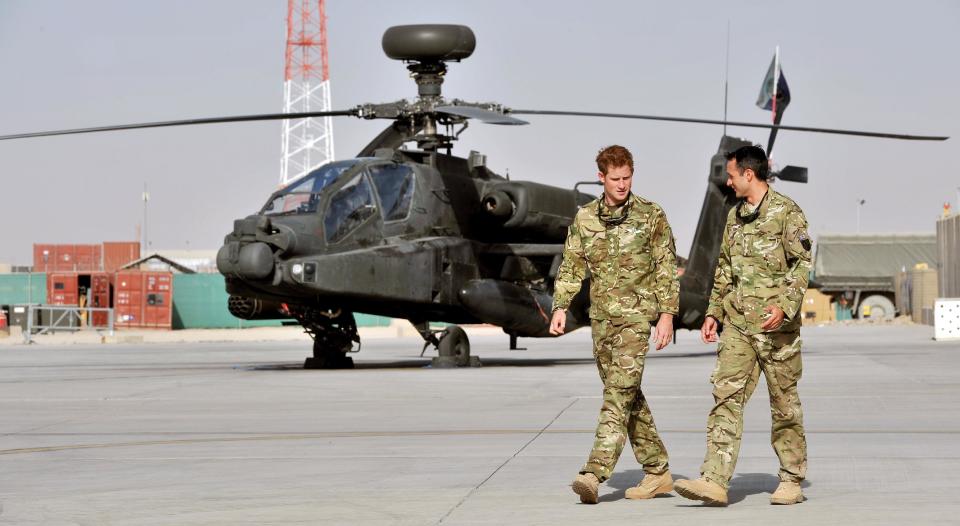 Britain's Prince Harry is shown the Apache flight-line Friday Sept 7 2012 by a member of his squadron (name not provided) at Camp Bastion in Afghanistan, where he will be operating from during his tour of duty as a co-pilot gunner. The Prince has returned to Afghanistan to fly attack helicopters in the fight against the Taliban. (AP Photo/ John Stillwell, Pool)