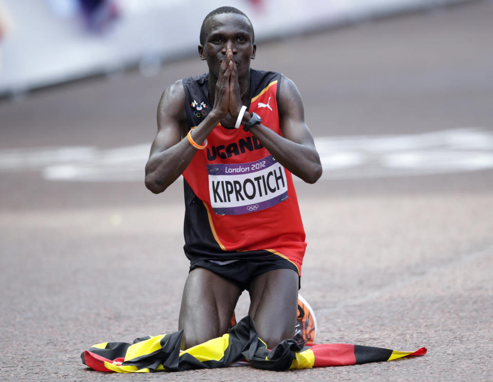 Uganda's Stephen Kiprotich kneels on the ground as he celebrates winning the men's marathon in the London 2012 Olympic Games at The Mall August 12, 2012. REUTERS/Max Rossi (BRITAIN - Tags: SPORT ATHLETICS OLYMPICS TPX IMAGES OF THE DAY) 